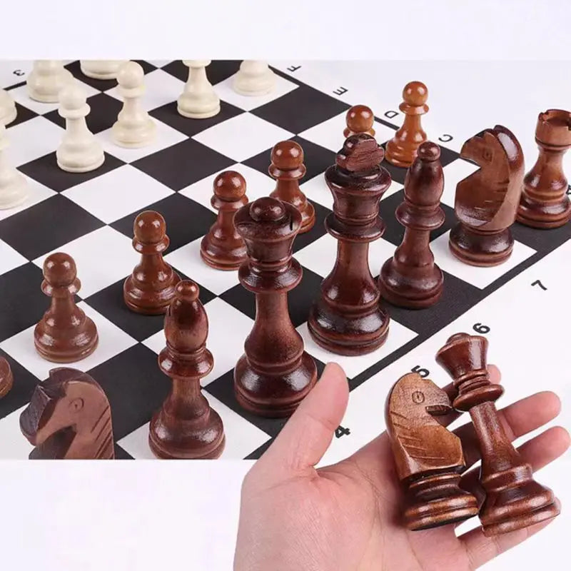 Pièce d'échecs en bois tenue en main au-dessus du plateau souple